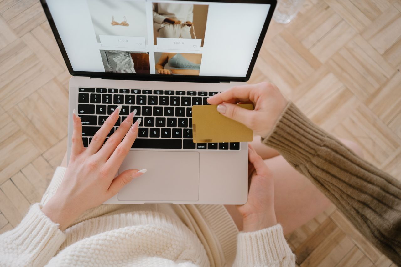 Osoba kupuje online koristeći laptop i kreditnu karticu, ističući praktičnost e-trgovine.